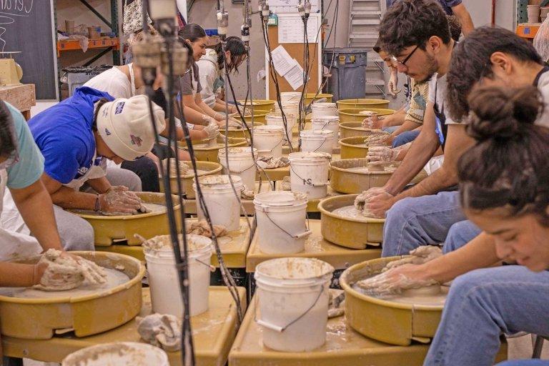 members of the latinx student union try their hand at throwing pottery in Tim Berg's studio